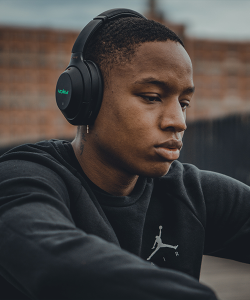En ung man som lyssnar på musik med hörlurar av märket Voky